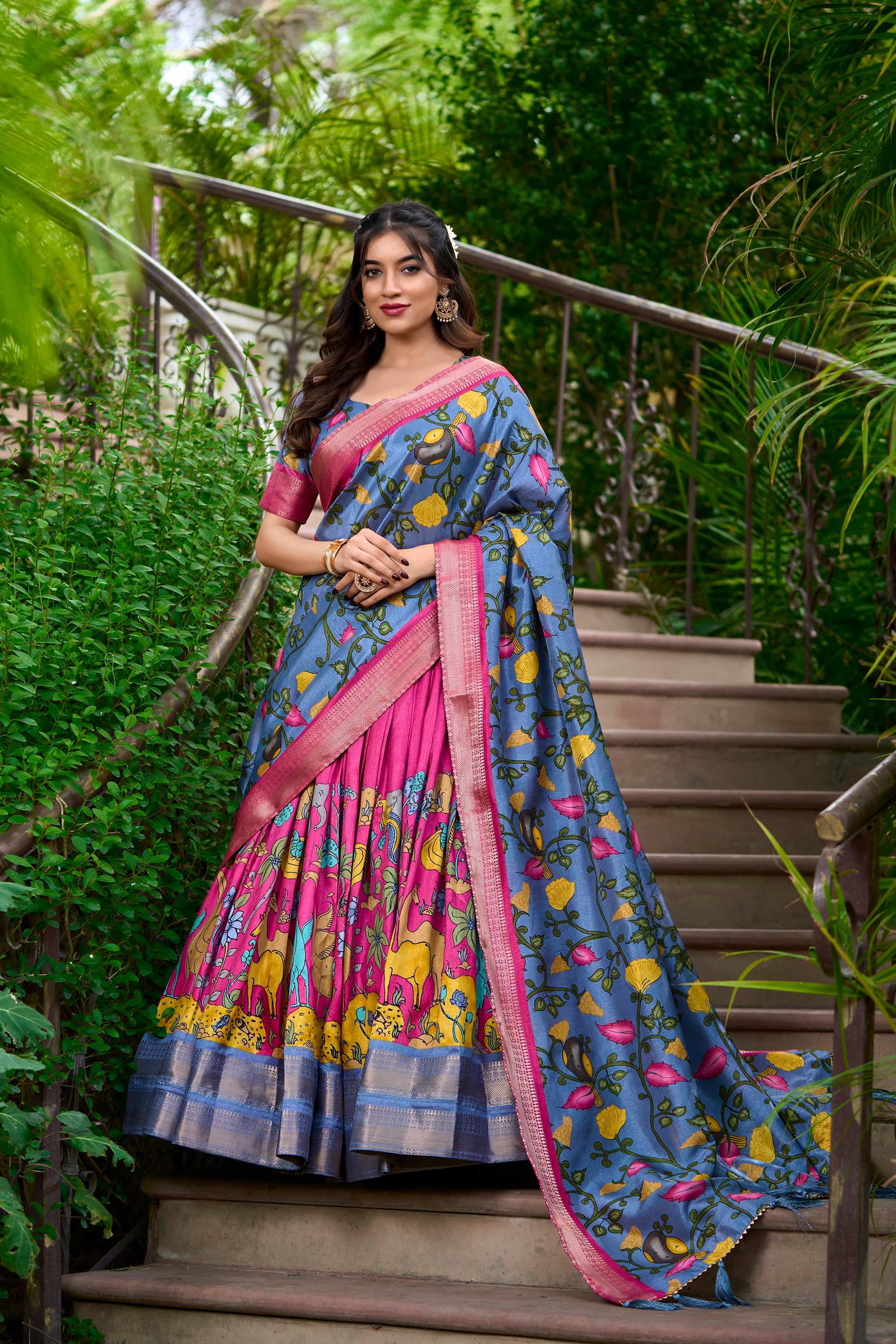 A woman in a vibrant sari gracefully stands on steps, showcasing the beauty of traditional attire and cultural elegance