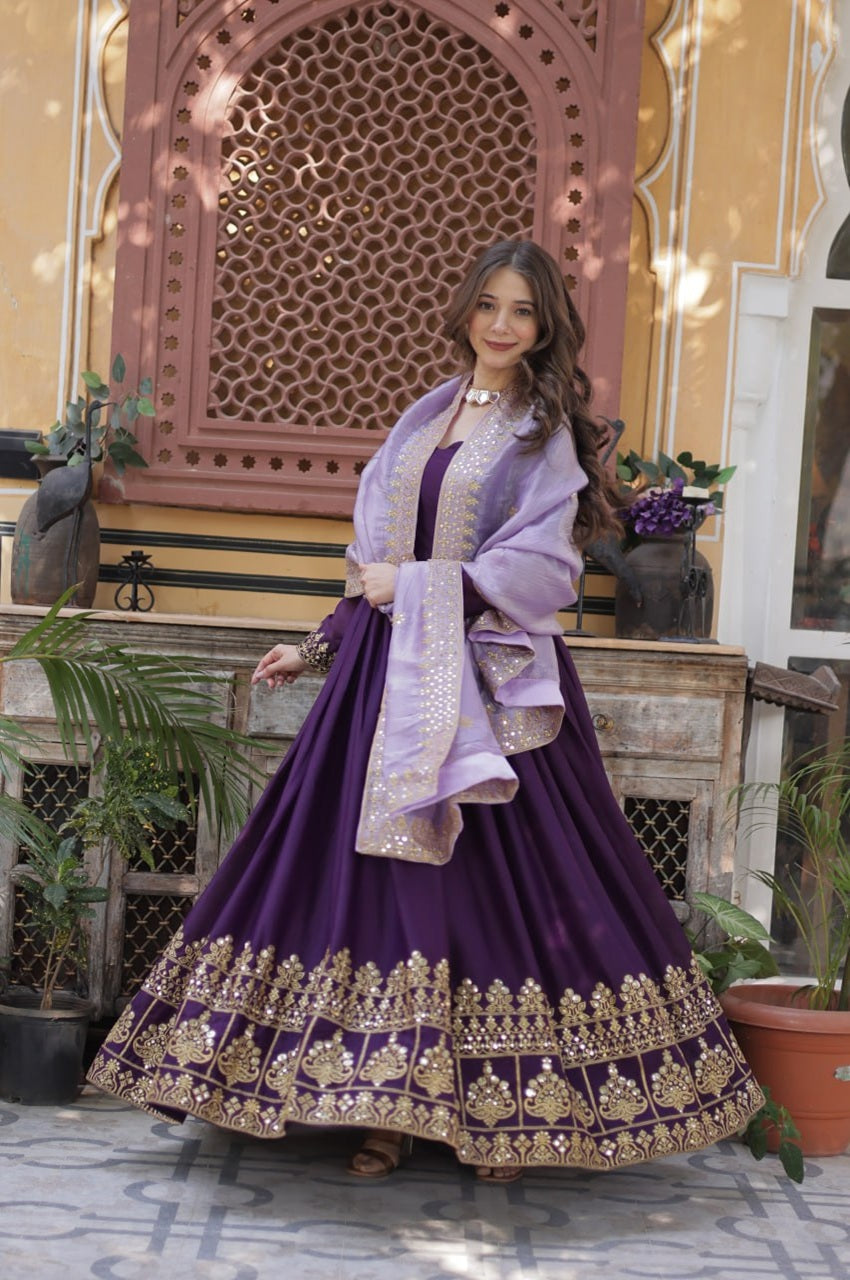 Woman in a traditional outfit with a purple dress and lavender shawl in an ornate setting.