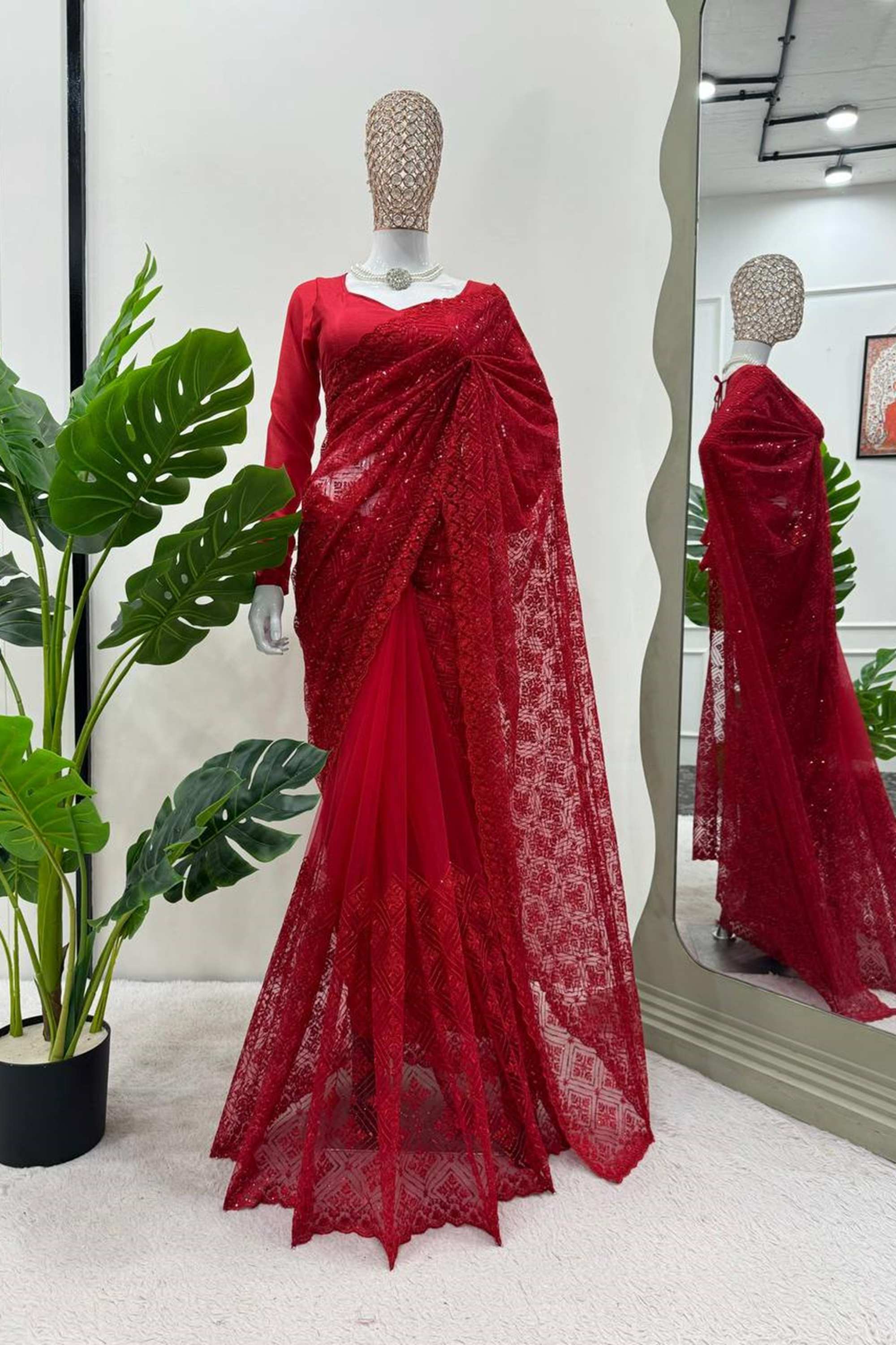 A stunning red sari adorned with intricate lace and delicate net detailing, perfect for elegant occasions and celebrations.