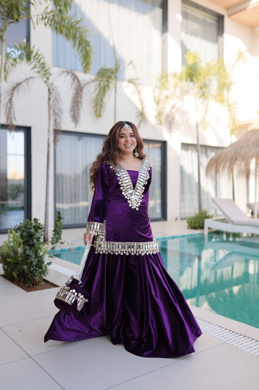 Woman in a purple dress with silver embellishments standing by a pool.