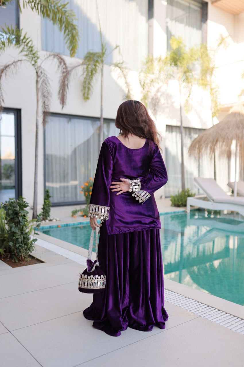 Woman in a purple outfit standing by a pool with modern building and plants in the background
