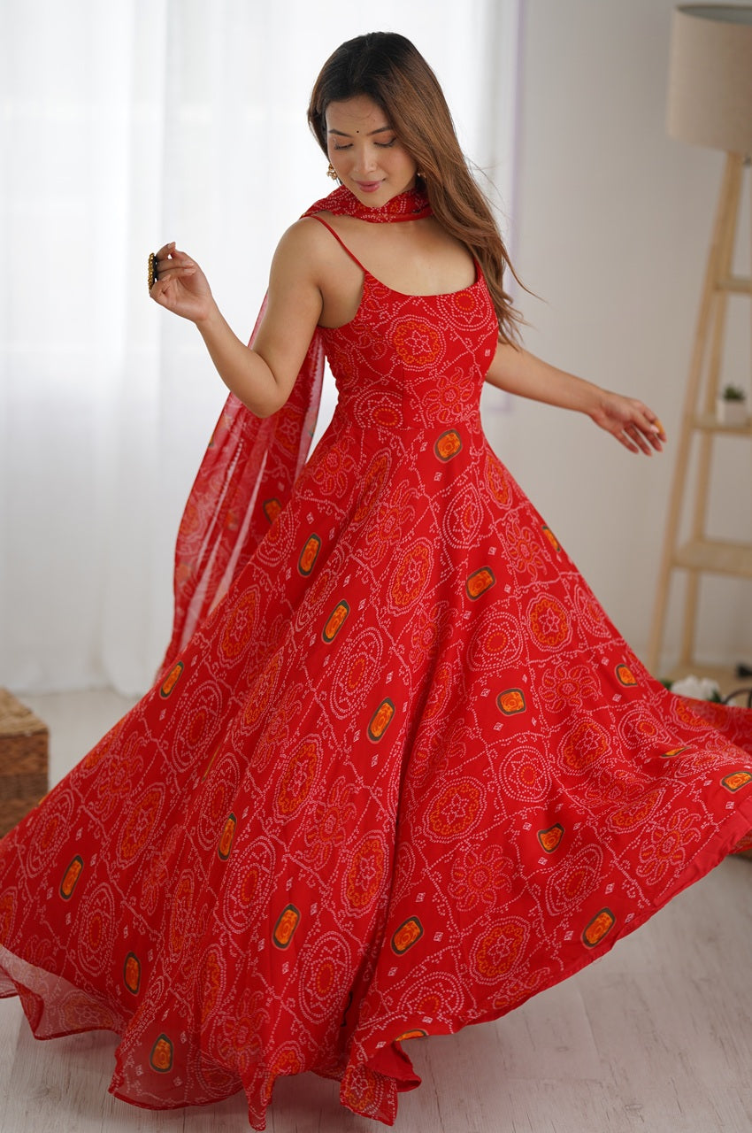 Woman in a red dress with floral patterns standing indoors.
