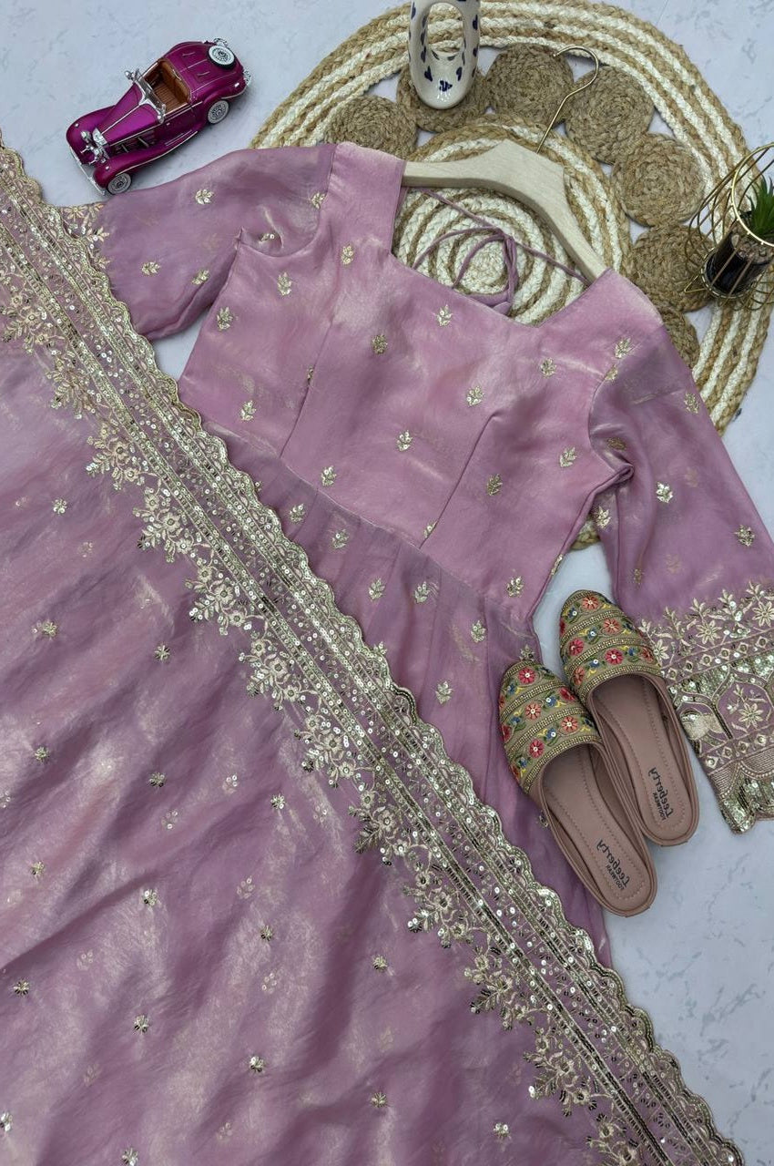 Purple saree with gold embroidery on a white surface, accompanied by a pink toy car and slippers.