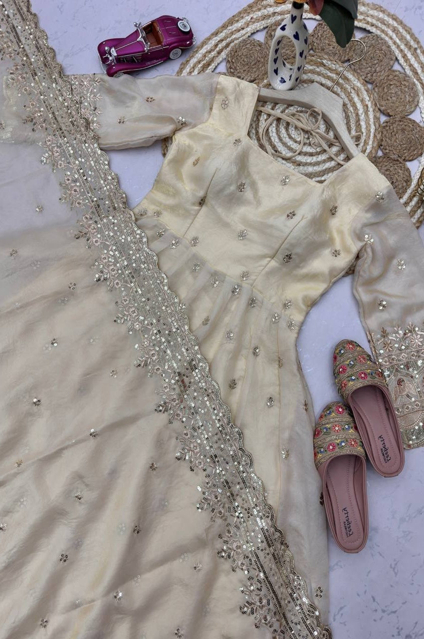 Decorative outfit with embellishments, sandals, and a small toy car on a textured surface.