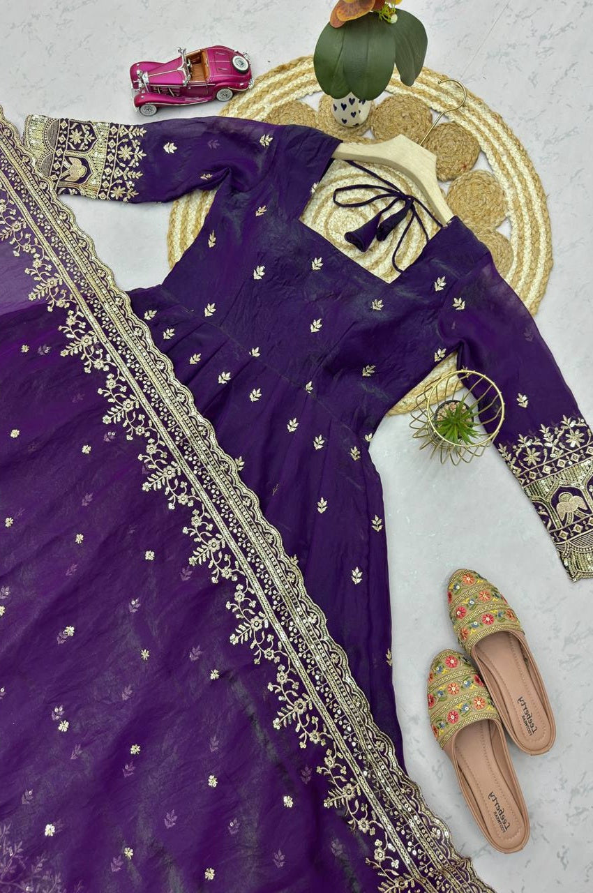 Purple embroidered outfit with a matching dupatta on a light gray surface.