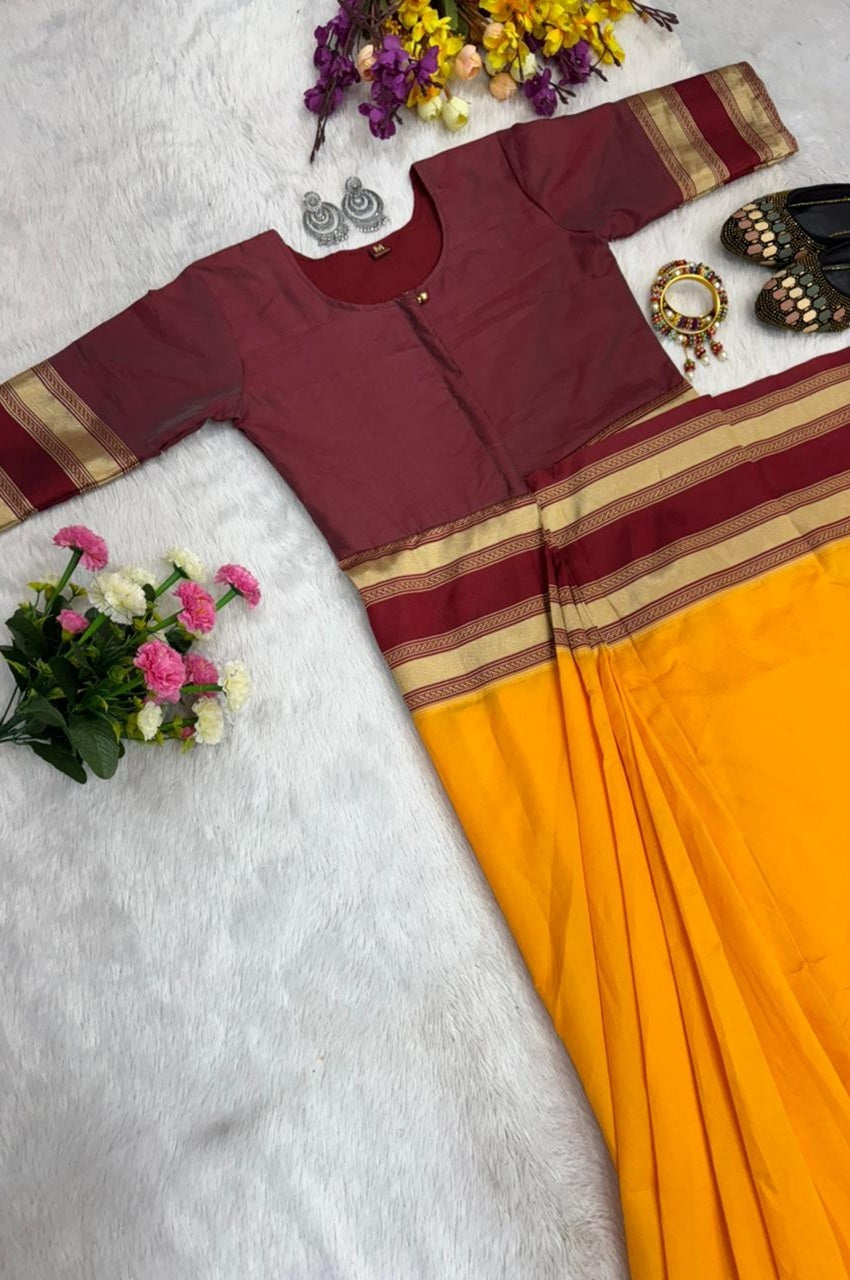 Maroon blouse with gold stripes and yellow saree on a light gray background with flowers and jewelry.