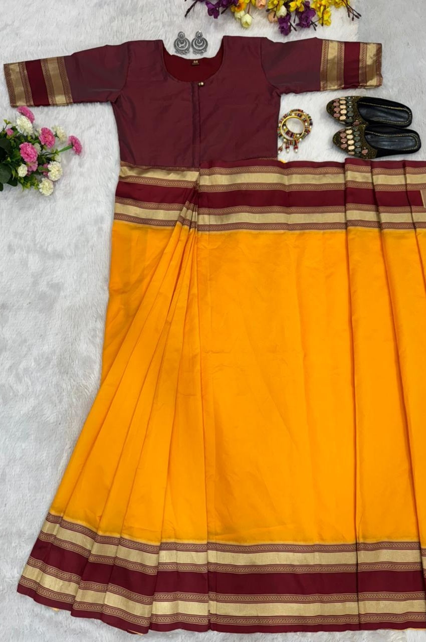 Yellow saree with maroon and gold border on a light gray background